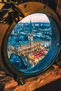 Top view of illuminated Christmas market on townhall square in advent time, Hamburg, Germany. Porthole window framed view. Top view of illuminated Christmas market on townhall square in advent time, Hamburg, Germany. Porthole window framed view.